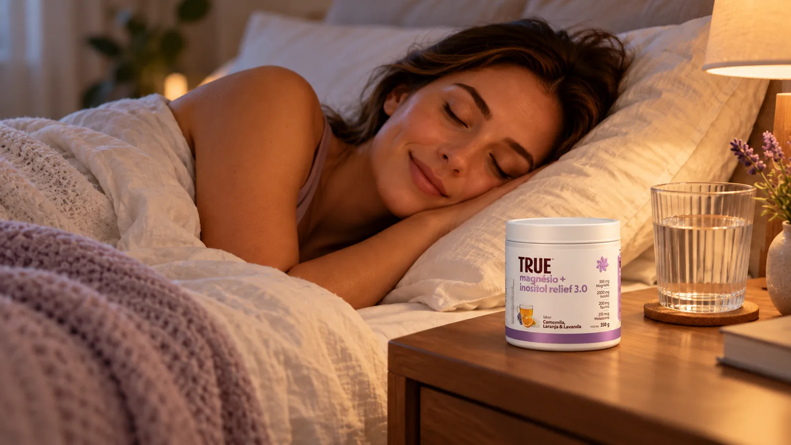 Mulher dorme em um quarto tranquilo, com um pote de Magnésio + Inositol Relief da True e água na mesa de cabeceira.